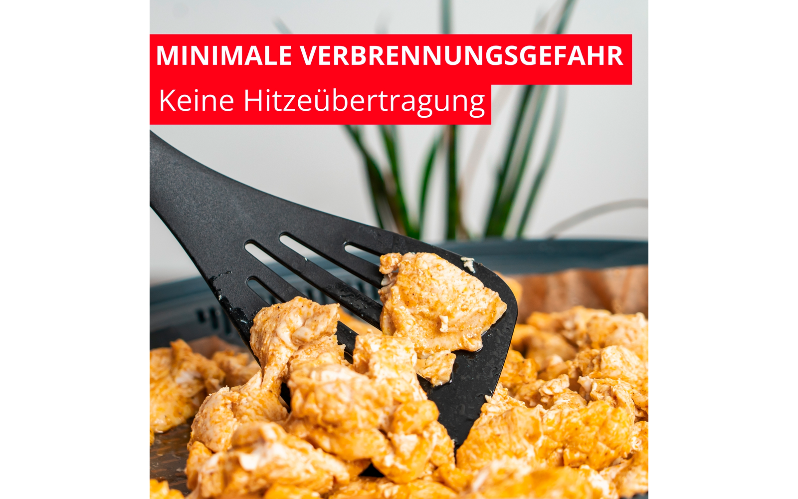 Spatule noire fendue soulève des morceaux alimentaires dorés et friables dans une poêle; en haut à gauche bannière rouge avec texte allemand en blanc 'MINIMALE VERBRENNUNGSGEFAHR' et 'Keine Hitzeübertragung'; plante verte floue en arrière-plan