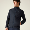 Person mit dunkler gesteppter Jacke mit Frontreißverschluss und sichtbarer Brusttasche, rechte Hand in Seitentasche, Blick nach rechts, heller einfarbiger Hintergrund
