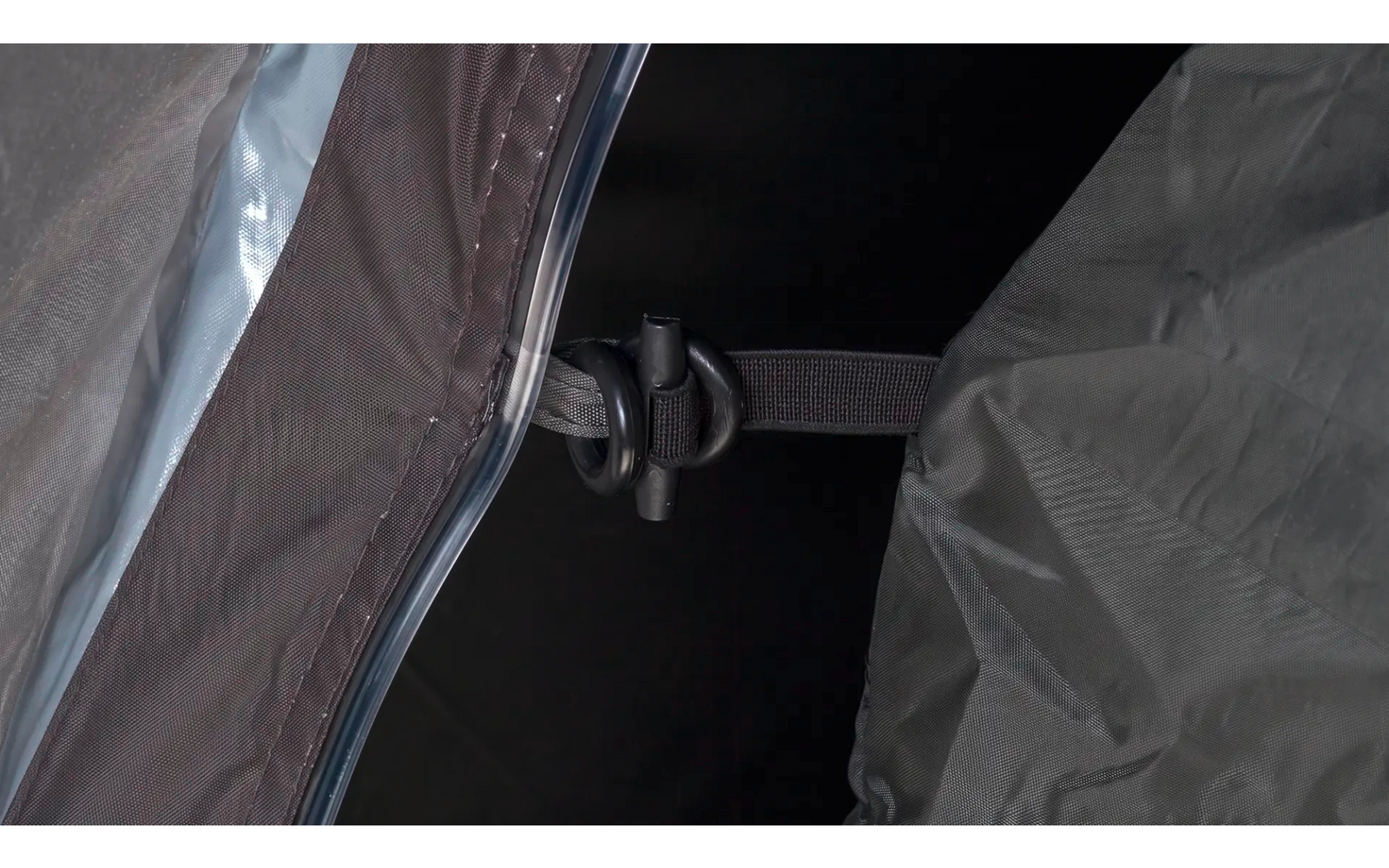 Close-up van twee stofpanelen, een zwarte kunststofclip, twee bandjes en een halfdoorzichtige kunststofstrip tegen een donkere achtergrond