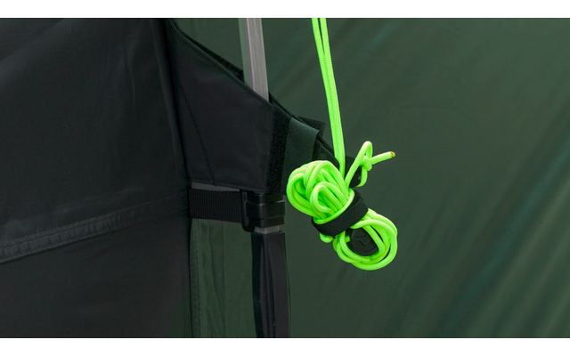 Close-up van een neongroene koord, geknoopt en bevestigd aan een zwarte band met gesp op een groene tent