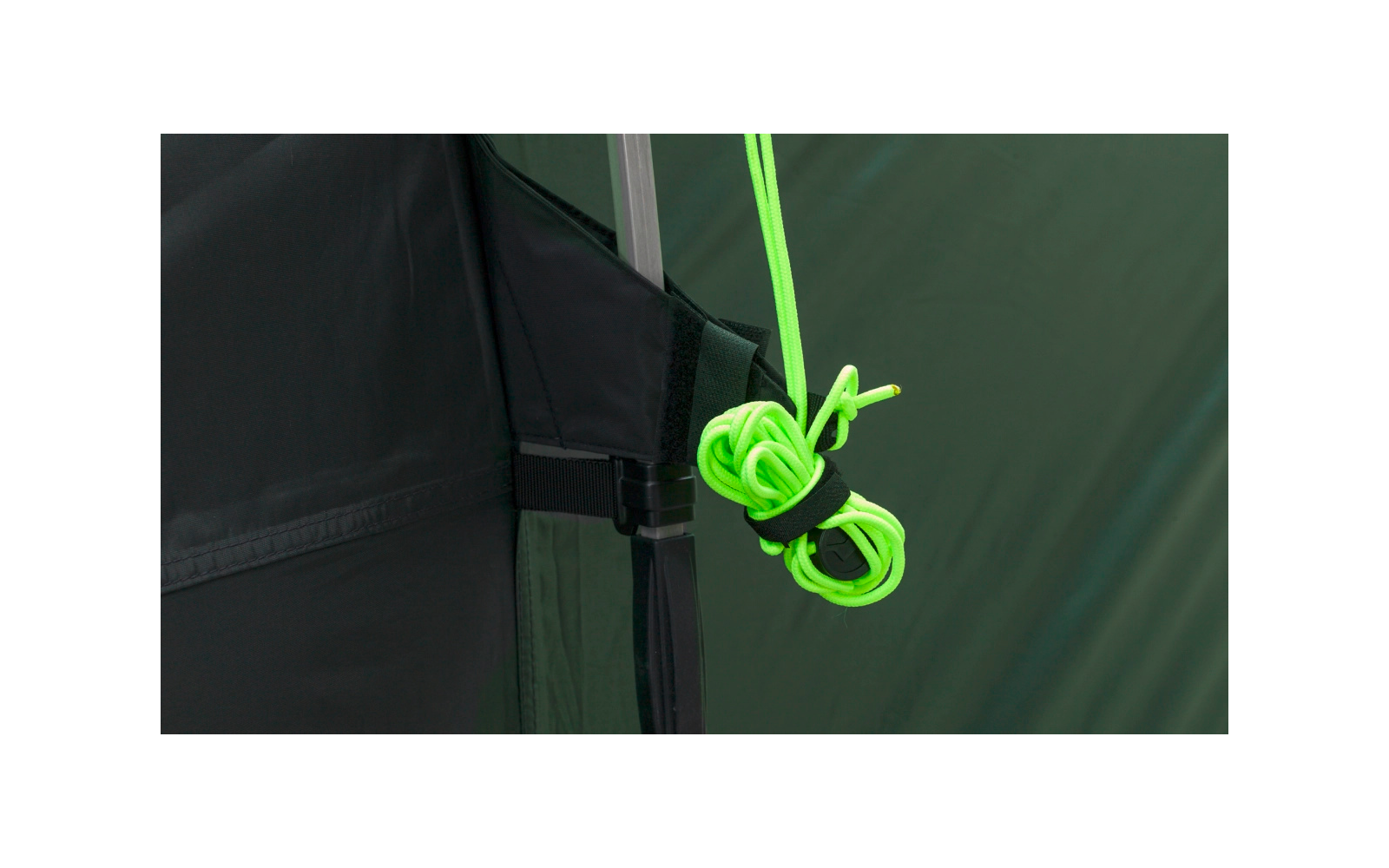 Close-up van een neongroene koord, geknoopt en bevestigd aan een zwarte band met gesp op een groene tent