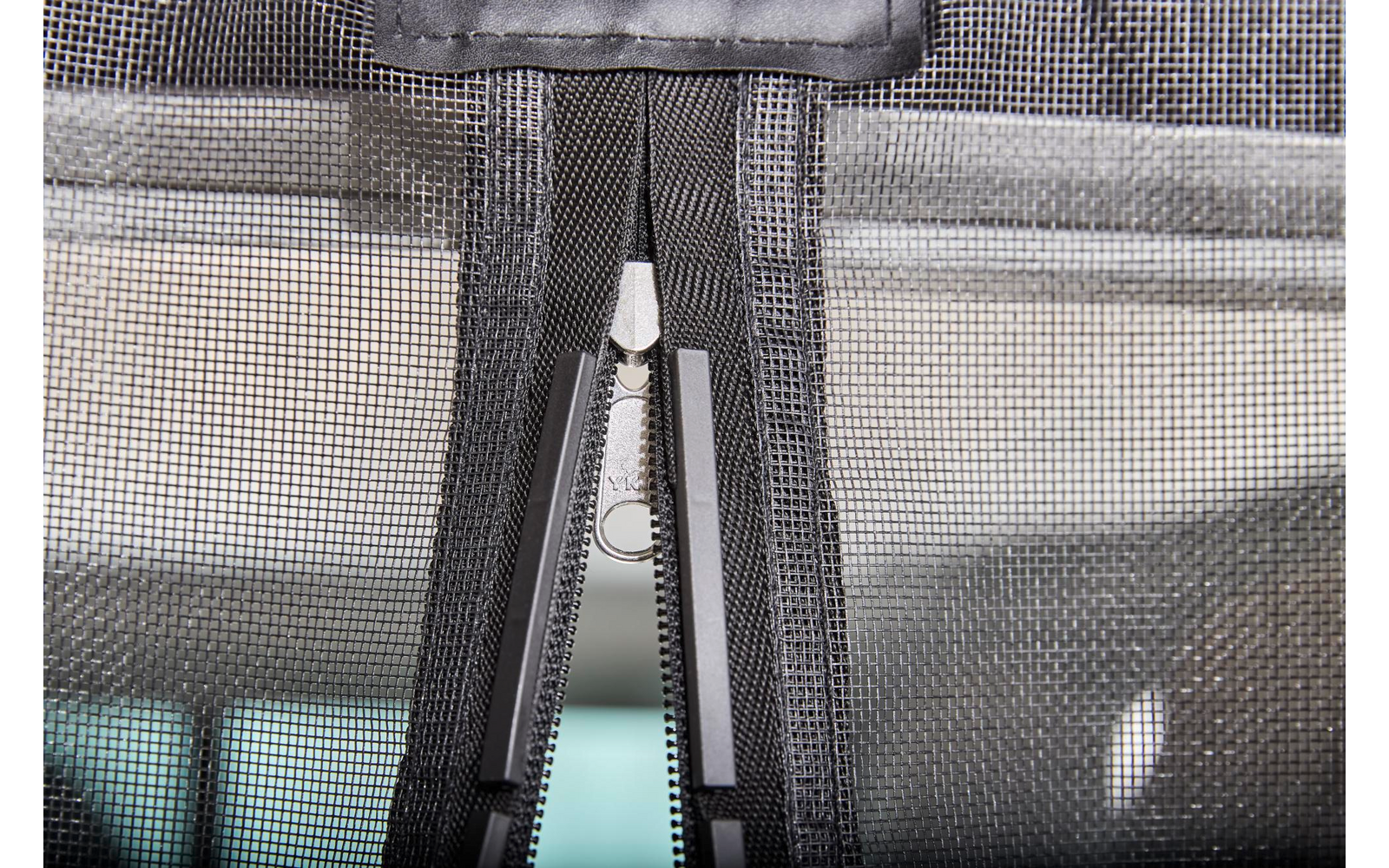 Nahaufnahme eines Reißverschlusses an einem grauen Stoff