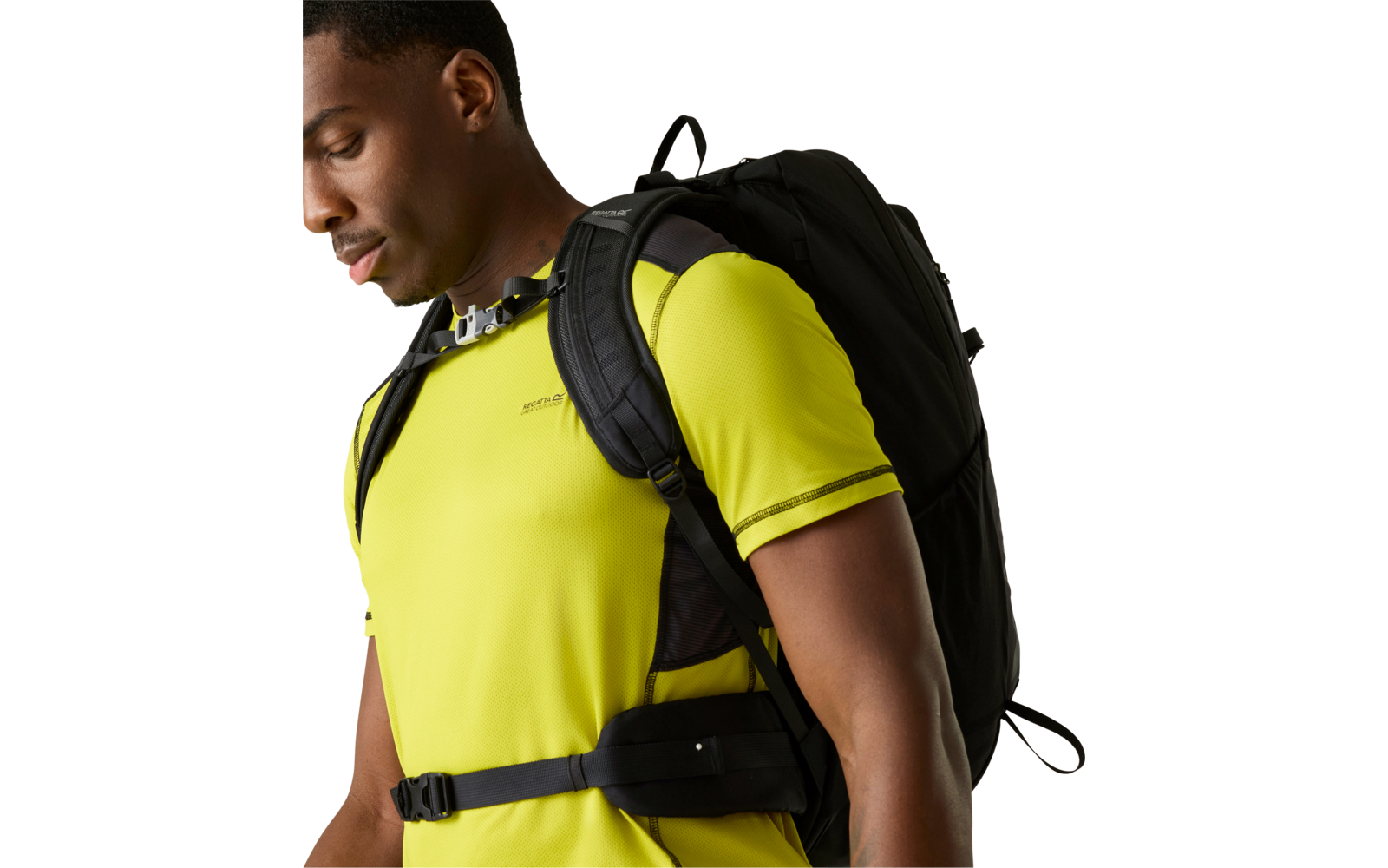 Seitliche Ansicht einer Person mit gelbem T-Shirt und schwarzem Rucksack mit Brust- und Hüftgurt