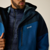 Unteres Gesicht und Oberkörper, gesteppte Innenjacke unter blauer Außenjacke mit Regatta-Logo; Hand an Reißverschluss