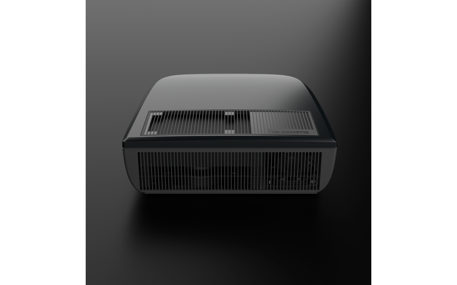 Black rounded rectangular device with ventilation grilles on top and front, small slider on top, on a dark background