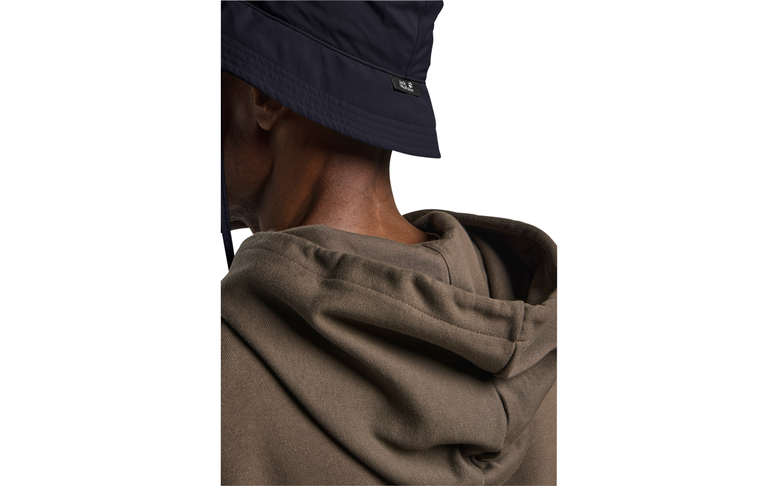 Rückenansicht einer Person mit dunkelblauem Anglerhut und braunem Kapuzenpullover