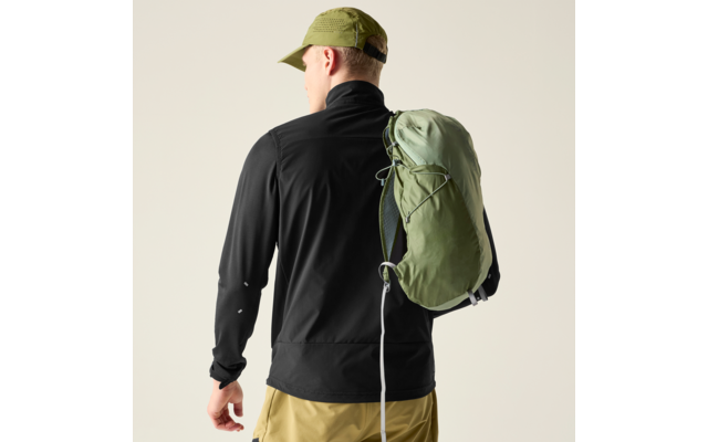 Person von hinten, trägt schwarze Jacke, hellgrünes Cap, khakifarbene Hose und einen grünen Rucksack über einer Schulter