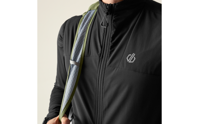 Oberkörper ohne Gesicht, schwarze Jacke mit durchgehendem Reißverschluss und kleinem weißem Logo auf der Brust, Hand hält grünen Rucksackgurt über der Schulter