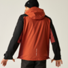 Person von hinten in orange-roter Jacke mit schwarzen Ärmeln und Kapuze und schwarzer Mütze, zieht an den Kordeln am Saum, vor hellem Hintergrund