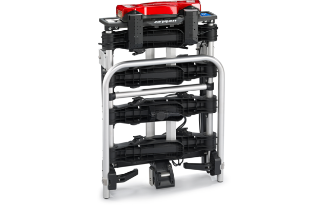 Gefaltetes, mehrlagiges schwarzes Gerät mit rotem Deckel, mehreren gestapelten schwarzen Plattformen/Schienen, silbernem Metallrahmen, sichtbarem Kabel und kleinem schwarzem Gehäuse unten