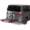 Heck eines grauen Vans mit an der Anhängerkupplung montiertem Fahrradträger mit mehreren Halterungen und Kennzeichen 'UEBLER'