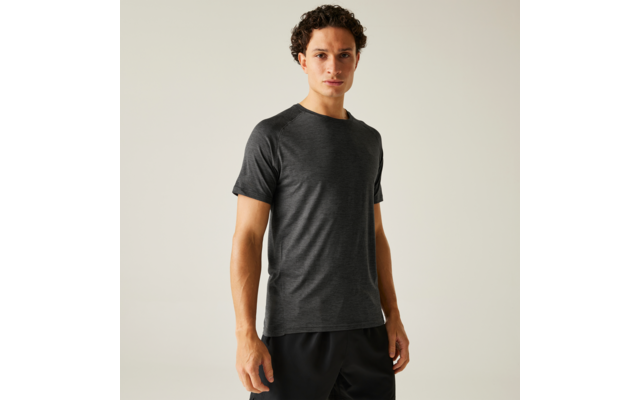 Personne debout en t-shirt gris foncé et short noir devant un fond clair