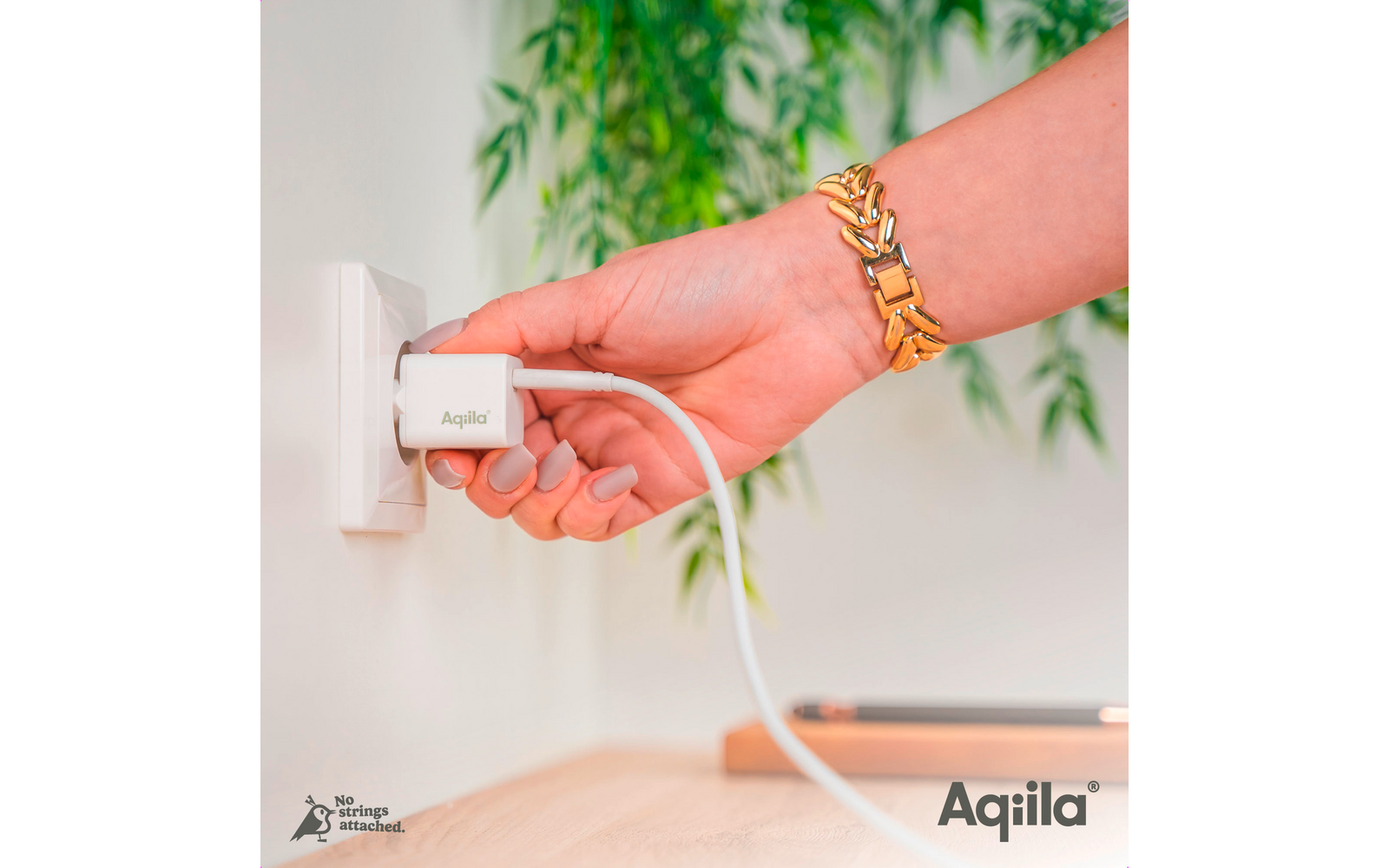 Hand steckt einen weißen Stecker in eine Steckdose mit grünem Hintergrund