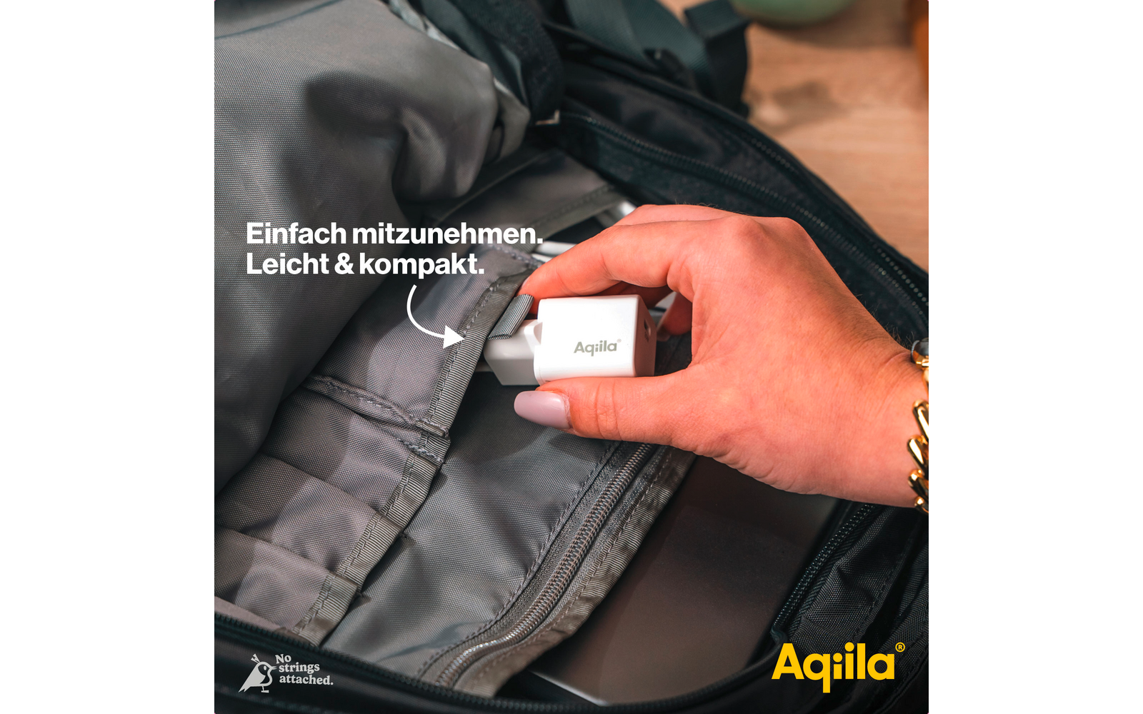 Hand legt eine weiße Powerbank in eine graue Rucksacktasche