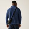 Mann von hinten in blauem Pullover mit Umhängetasche