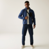 Mann trägt blaue Jacke und blaue Hose vor weißem Hintergrund