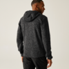 Ein Mann trägt einen dunklen Kapuzenpullover und steht mit dem Rücken zur Kamera