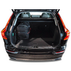 Coffre ouvert d'une voiture noire avec un sac à dos noir à gauche, sièges arrière visibles et plancher de chargement recouvert de moquette