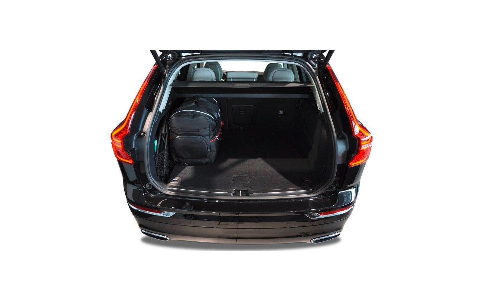Coffre ouvert d'une voiture noire avec un sac à dos noir à gauche, sièges arrière visibles et plancher de chargement recouvert de moquette