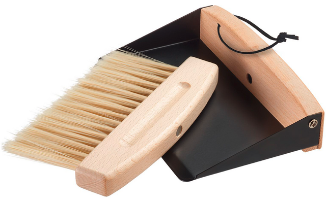 Hand brush with light wooden handle and light bristles beside a black metal dustpan with wooden front edge and hanging cord