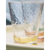 Verre texturé vide sur une table blanche