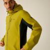 Oberkörper einer Person in gelbgrüner Kapuzenjacke mit schwarzem Seiteneinsatz, Hände am Jackensaum, Blick nach links