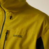 Nahaufnahme einer gelben Jacke von Schulter und Brust mit Wassertropfen, Reißverschluss, Brusttasche und Aufschrift "Regatta Great Outdoors"