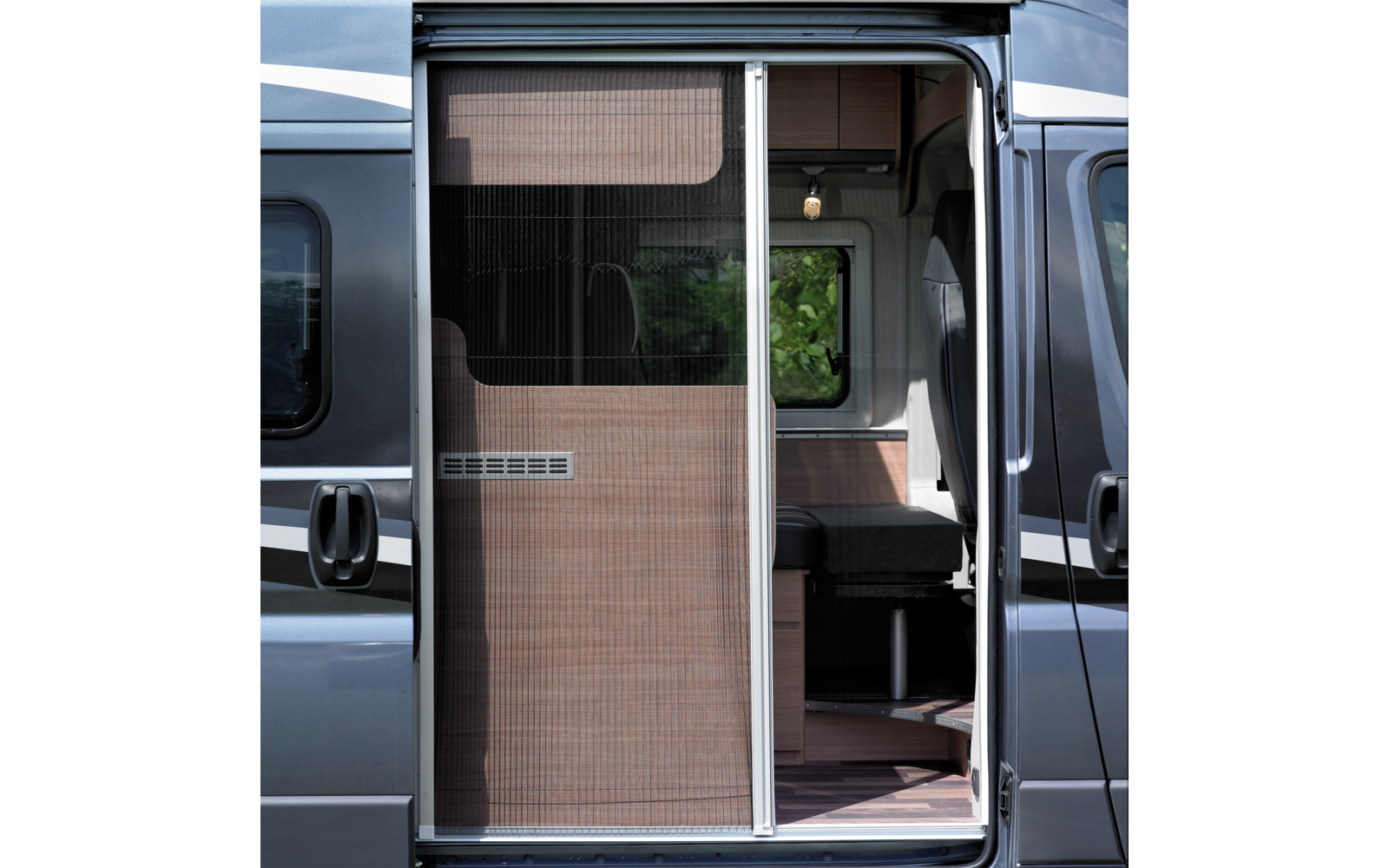 Opengeschoven schuifdeur van een camper met hor; interieur met zitbank, raam en hanglamp