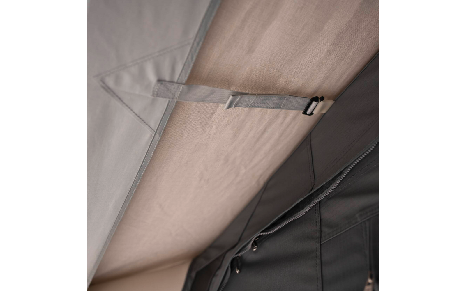 Beiges Innenfutter und grauer Stoff mit angenähtem Gurt mit Kunststoffschnalle und sichtbarem Reißverschluss