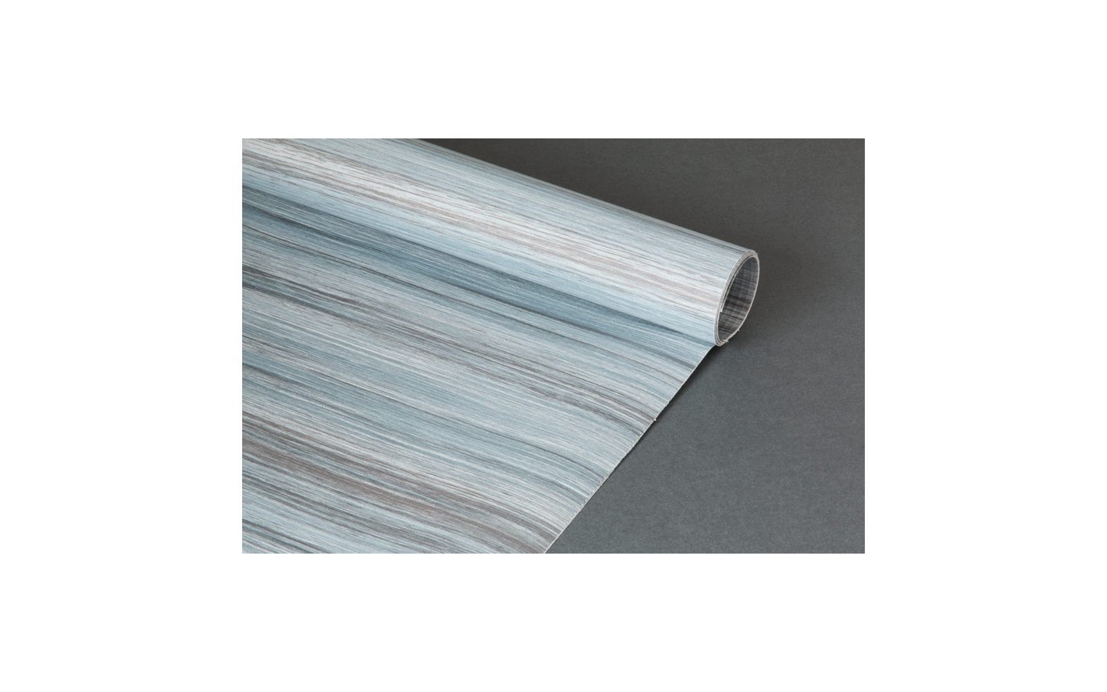 Aufgerolltes Blatt mit blau-grauer Holzmaserung auf dunkelgrauem Hintergrund