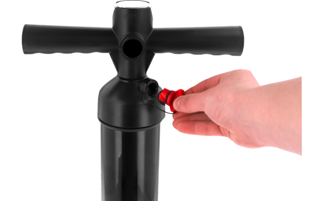 Hand holding a red valve/connector on the side of a black pump with a T-shaped handle and cylindrical body