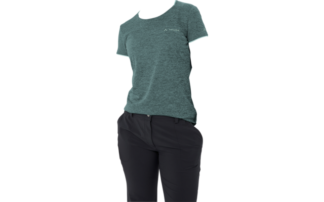 Persona con capelli raccolti in coda, T‑shirt verde acqua a maniche corte con piccolo logo, pantaloni neri, in posizione laterale, sguardo verso destra, sfondo bianco