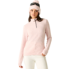 Person mit hellrosa Strickmütze mit Bommel und daraufgelegter Sonnenbrille, hellrosa Langarmpullover mit kurzem Reißverschluss und weißer Hose, steht mit einer Hand in der Tasche