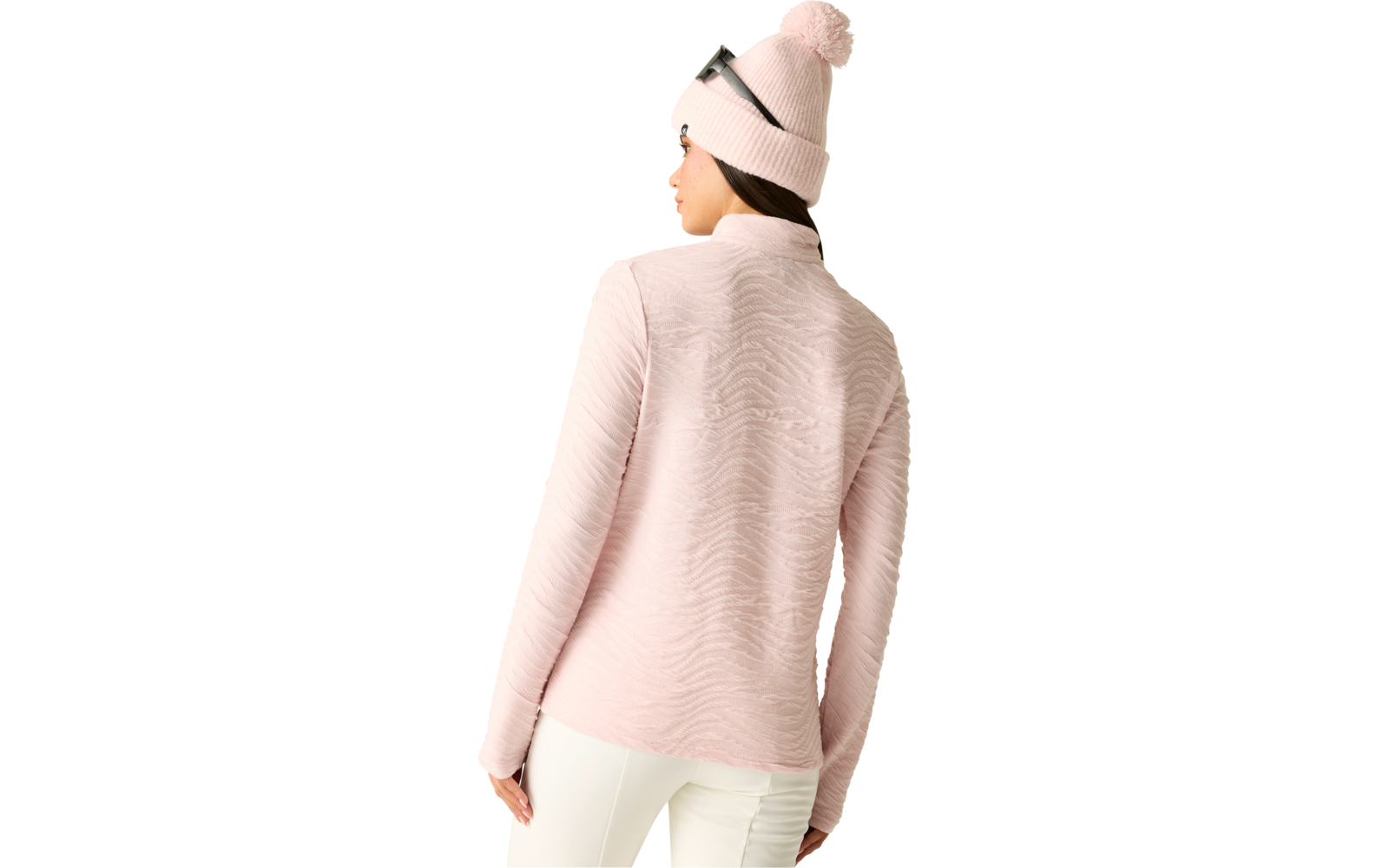 Person von hinten in rosa strukturierter Langarmjacke, weißer Hose, rosa Strickmütze mit Bommel und Brille auf der Mütze, heller Hintergrund