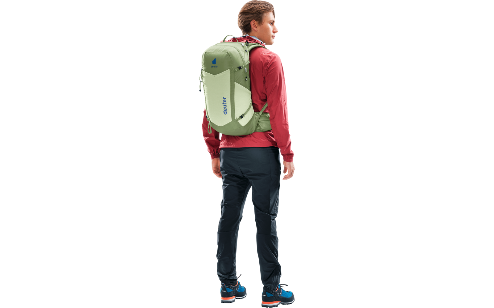 Person seitlich sichtbar mit grünem Rucksack, roter Jacke, dunkler Hose und Wanderschuhen