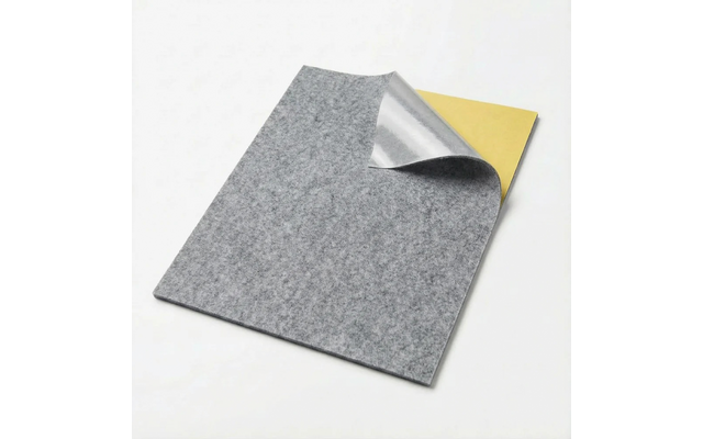 Grijs rechthoekig viltvel met een opgekrulde hoek, waarbij een zilverkleurige laag en een gele laag eronder zichtbaar zijn op een witte achtergrond