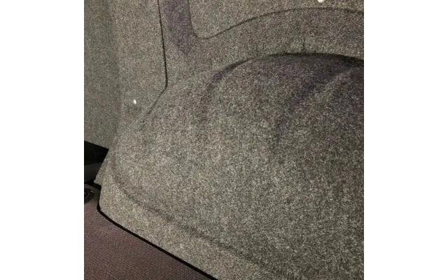 Grijze, gestructureerde vilt- of tapijtachtige oppervlakte met een afgerond verheven gedeelte en een zichtbare rand