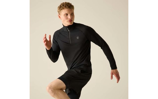 Personne aux cheveux blonds courts portant un haut de sport noir à manches longues et un short noir, pose de course sur fond clair