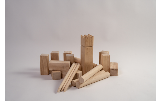 Houten bouwblokken en meerdere ronde houten pennen op witte achtergrond, midden een hoog blok met getande bovenrand