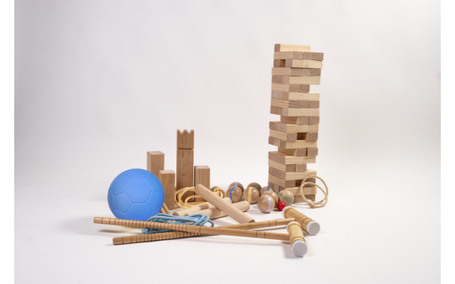Blauwe bal, diverse houten bouwblokken en houten speelgoed, hoge toren van houten blokken, meerdere houten staven en een springtouw op witte achtergrond