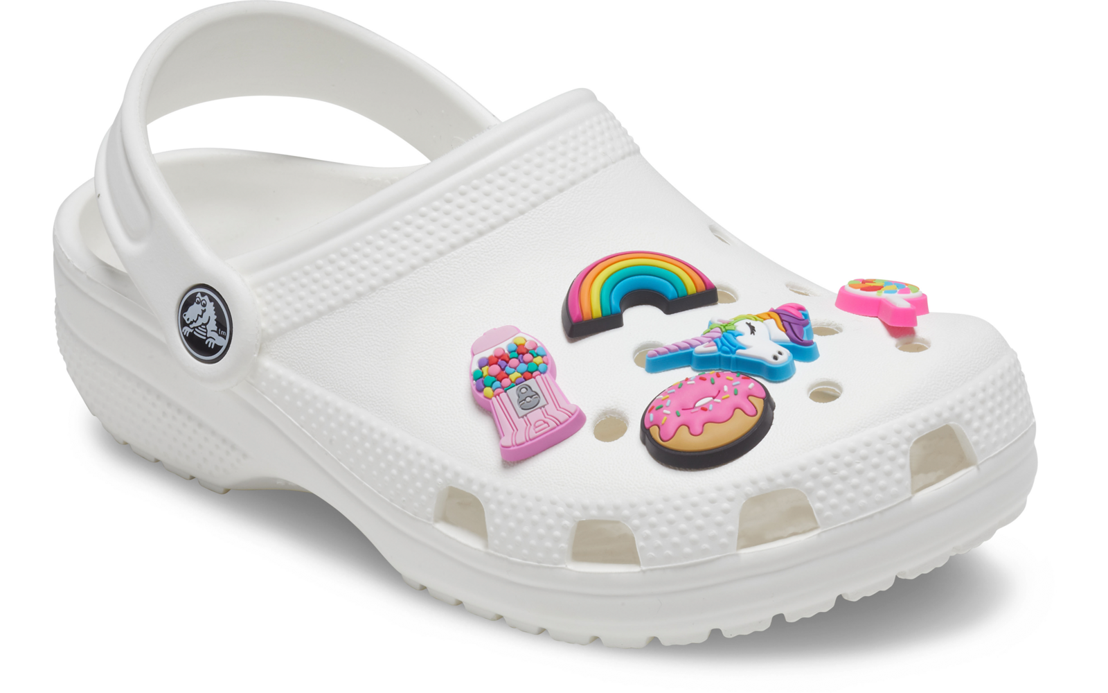 Zueco blanco con correa de talón y cinco dijes coloridos: arcoíris, unicornio, máquina expendedora de chicles, dona rosa glaseada, pequeño dije redondo