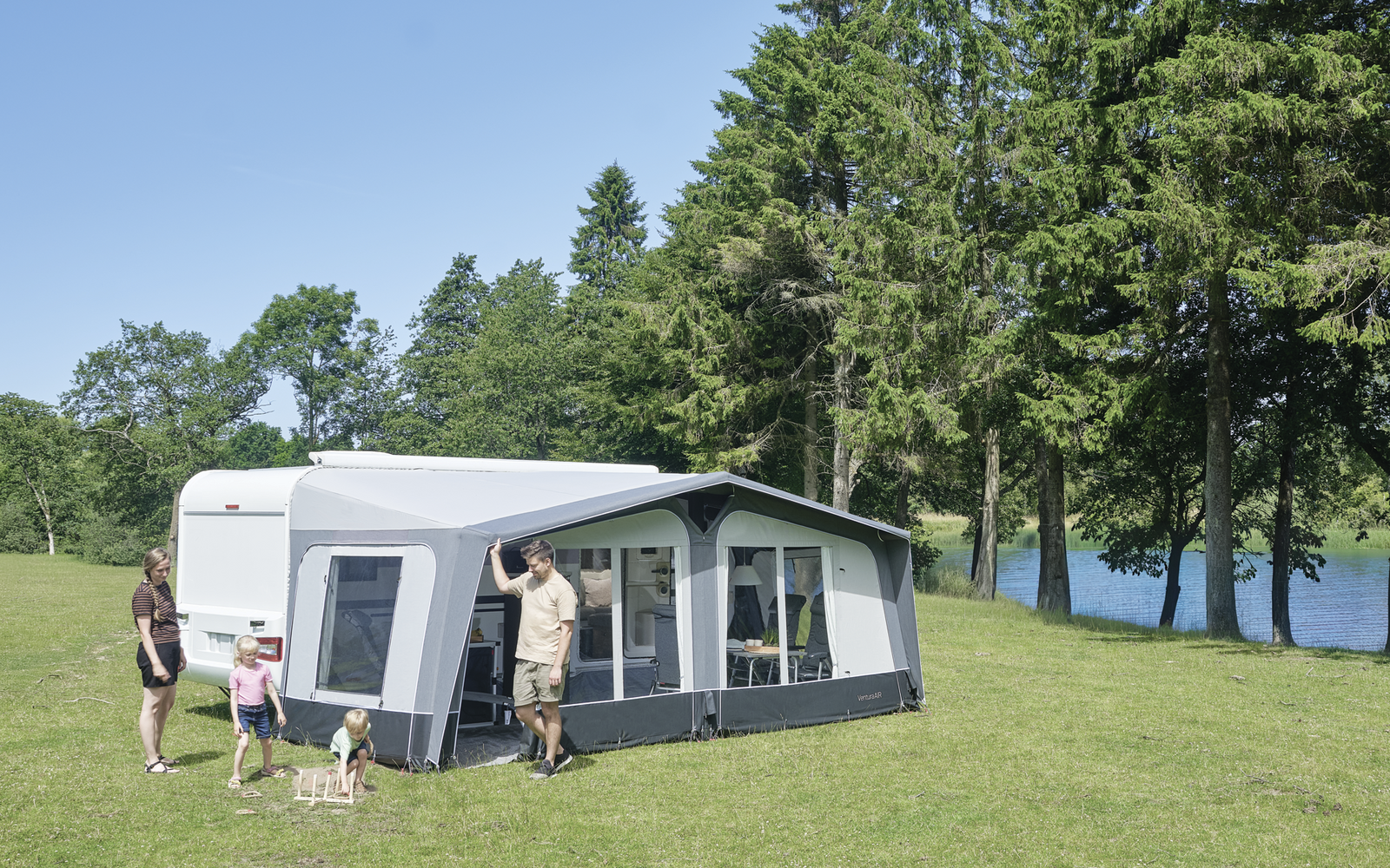 Barra metálica montada en un soporte redondo sobre una superficie vertical gris oscuro; una pieza de tela clara con una cremallera visible cuelga de la barra