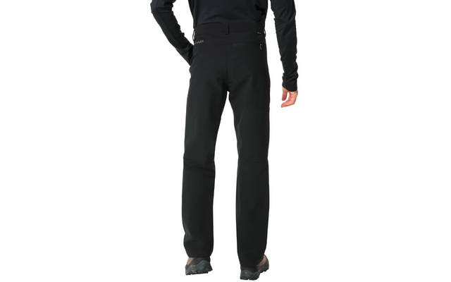 Person trägt schwarze Hose und schwarze Schuhe, nur Beine sichtbar