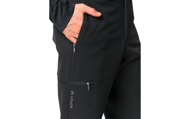 Hand steckt in der Hosentasche einer schwarzen Outdoorhose