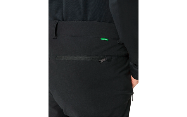 Teil einer Person von hinten, schwarze Hose mit Reißverschlusstasche und grünem Etikett