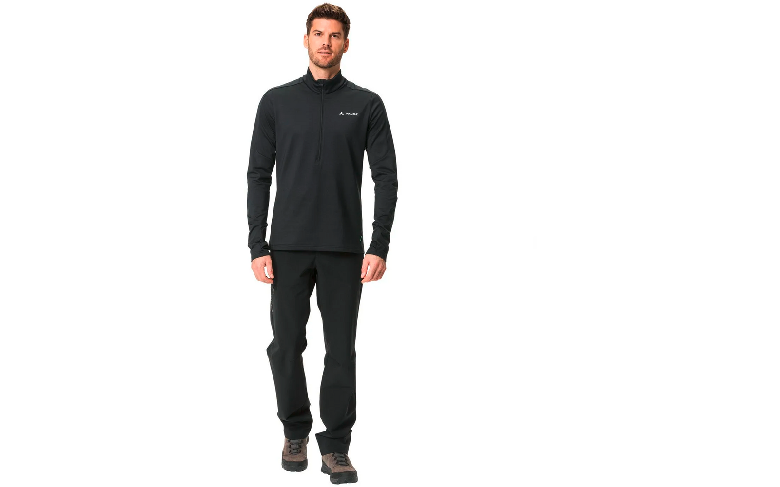 Mann in schwarzem Outdoor-Outfit steht frontal vor weißem Hintergrund