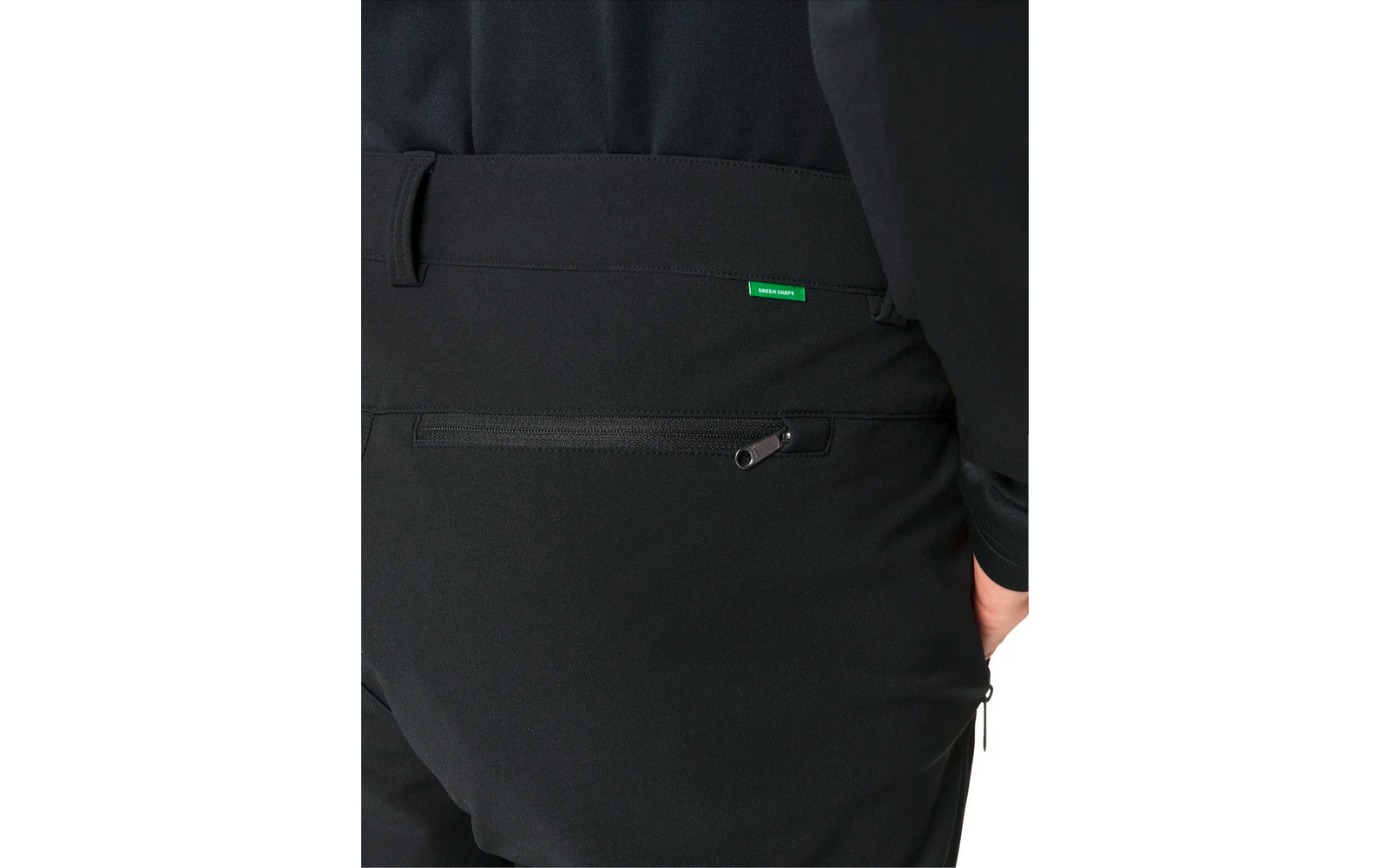 Teil einer Person von hinten, schwarze Hose mit Reißverschlusstasche und grünem Etikett
