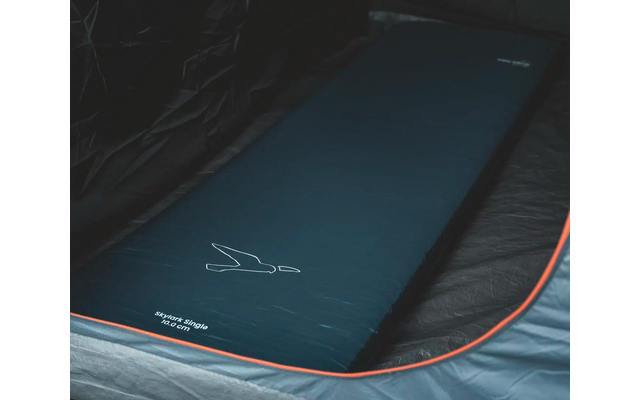 Schlafmatte mit schwarzer Oberfläche und oranger Umrandung auf dunkelgrauem Untergrund