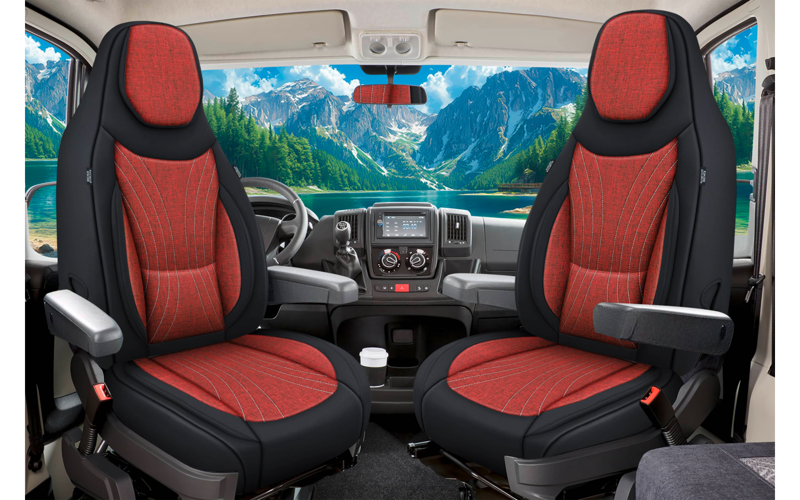 Vorderer Innenraum eines Fahrzeugs mit zwei rot-schwarzen Vordersitzen, Lenkrad und Armaturenbrett; durch die Windschutzscheibe Berge und ein See sichtbar