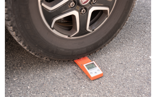 Neumático de vehículo sobre un dispositivo de medición rojo